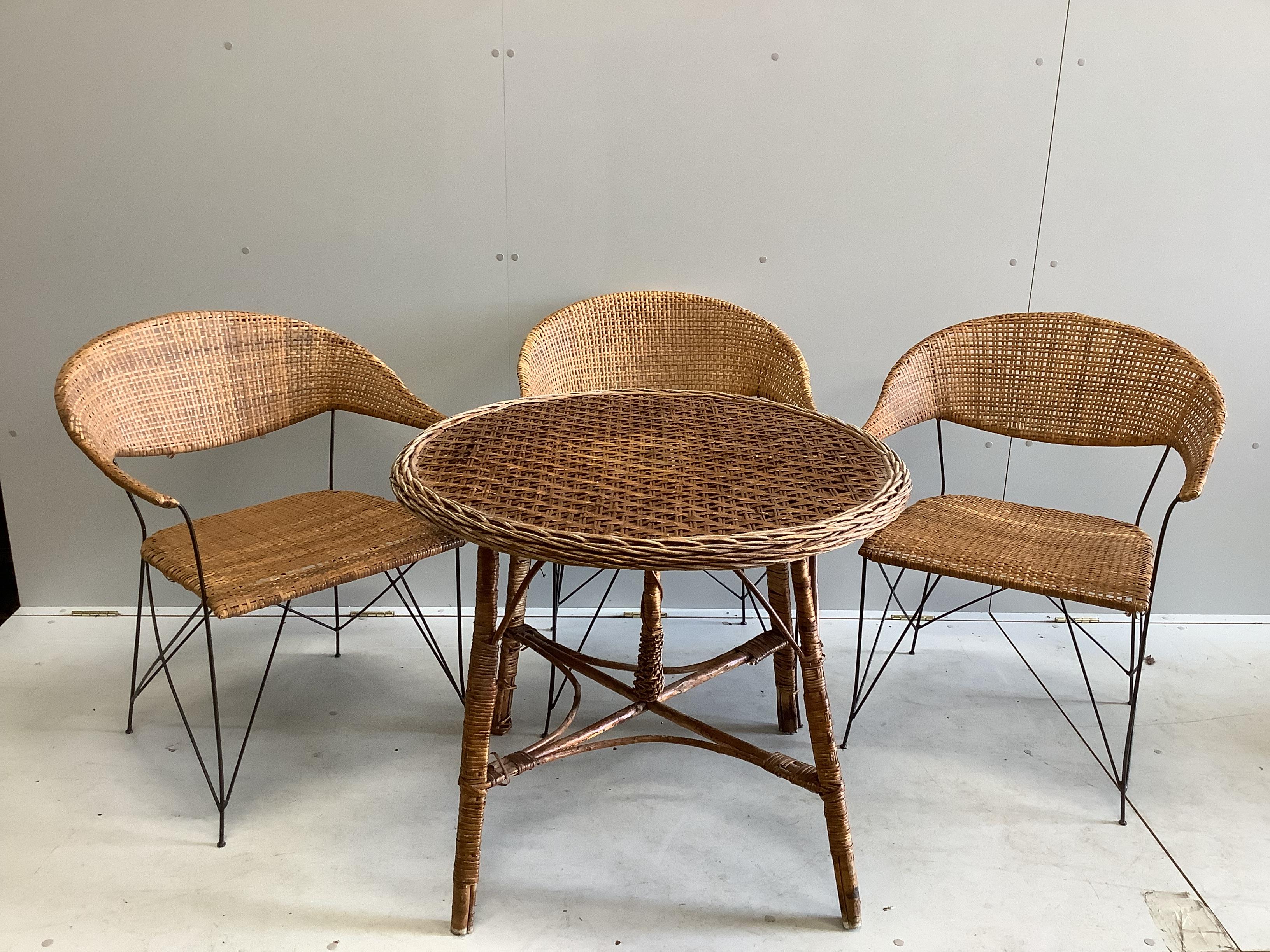 A circular wicker table, diameter 83cm, height 70cm together with three wicker tub framed chairs